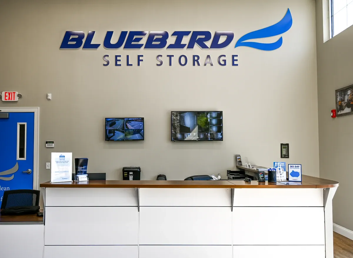 Bluebird Self Storage front desk with security monitors and branded logo