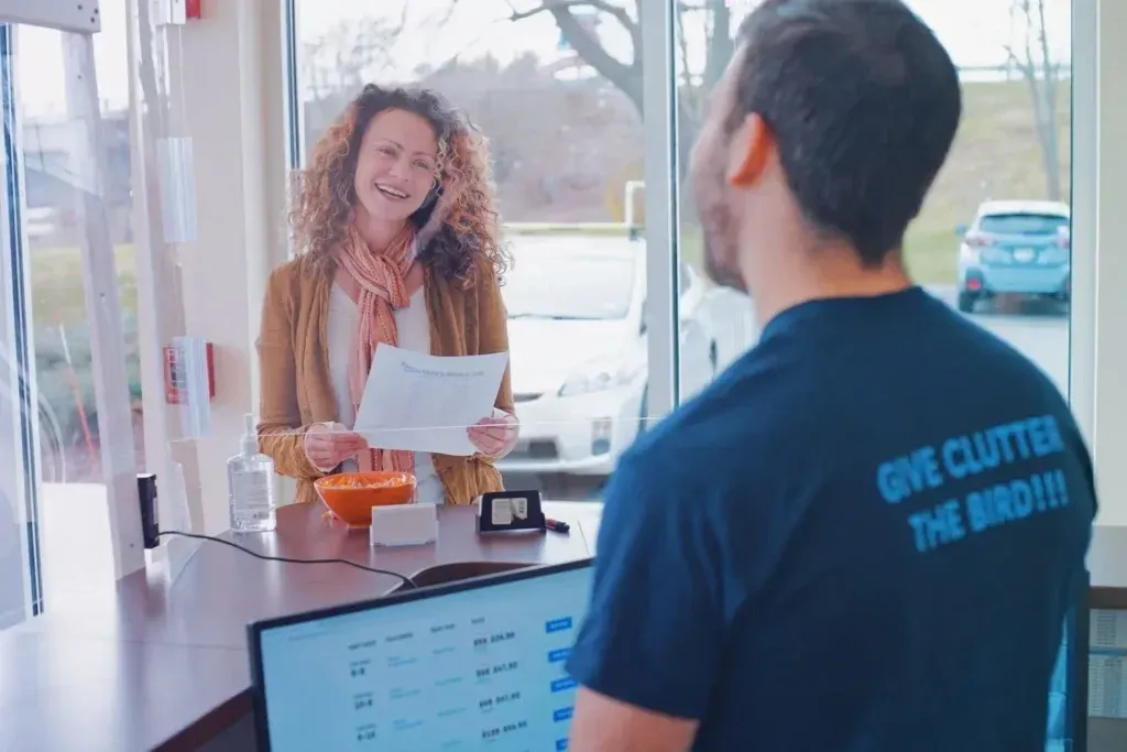 Customer and staff member at Bluebird Self Storage counter.