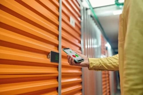 A person using a smartphone to securely lock their storage unit.