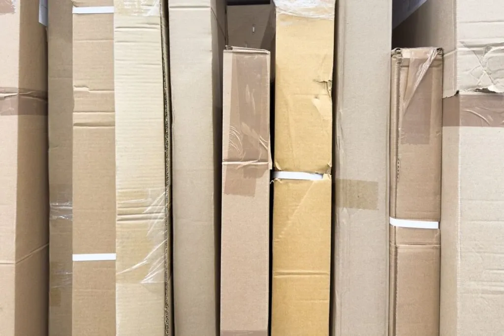 Tall and oblong cardboard boxes stand in a row