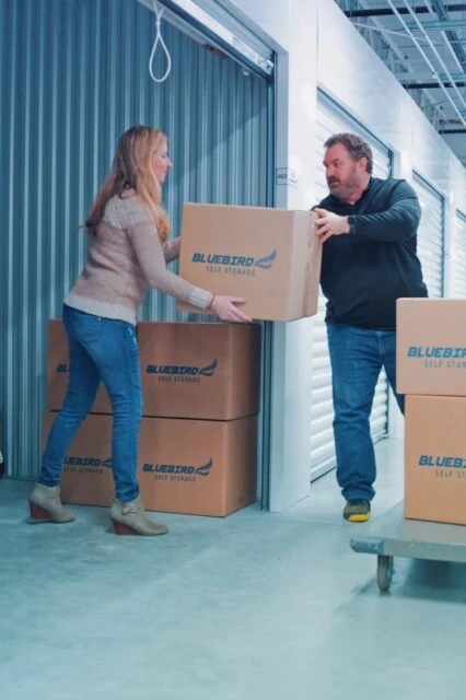 Man and woman organizing boxes in a climate control storage unit.